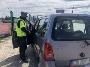 policjant kontroluje auto osobowe