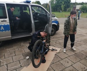 Policjant znakuje rower podczas festynu