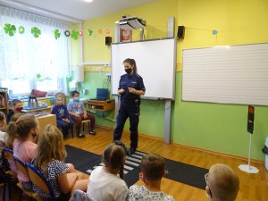 policjantka prowadzi zajęcia dla siedzących w klasie uczniów