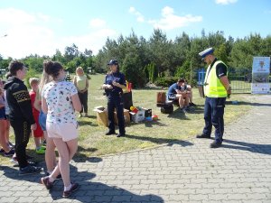 policjanci prowadzą na powietrzu pogadankę z uczniami