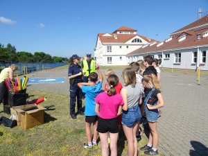 policjanci omawiają na boisku zasady ruchu rowerzystów