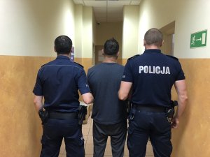 osoba zatrzymana prowadzona przez policjantów