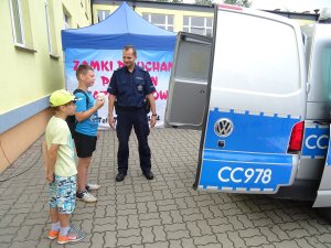 dzielnicowy pokazuje dzieciom radiowóz