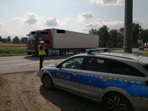 policjant mierzy prędkość aut jadących trasą