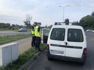 policjanci kontrolują białe auto dostawcze