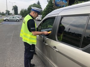policjant sprawdza trzeźwość kierowcy kontrolowanego auta