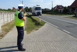 policjant mierzy prędkość auta urządzeniem