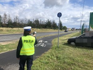 policjantka mierzy prędkość aut w rejonie ścieżki rowerowej