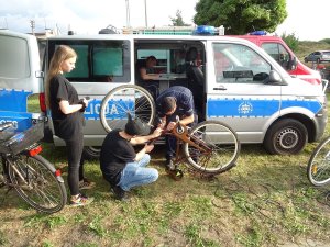 policjant znakuje rower, w tle radiowóz