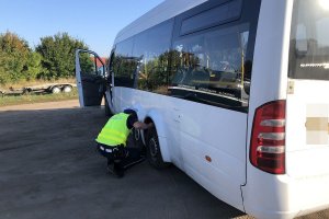 policjant sprawdza ogumienie pojazdu