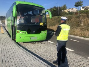 policjant kontroluje oświetlenie autokaru