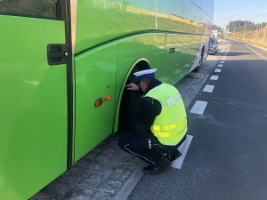 policjant sprawdza ogumienie autokaru