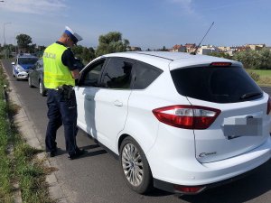 policjant kontroluje auto osobowe