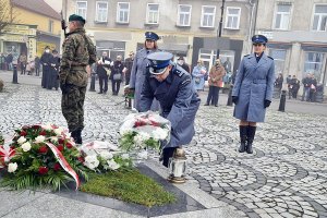 Komendant składa wiązankę pod pomnikiem na Rynku