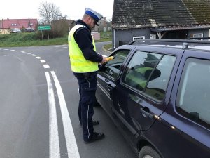 policjant kontroluje trzeźwość kierowcy auta osobowego