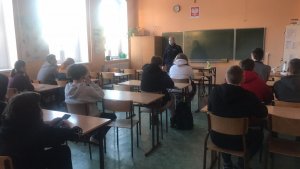 policjant prowadzi zajęcia dla uczniów siedzących w sali lekcyjnej