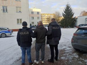 policjanci prowadzą osobę zatrzymaną