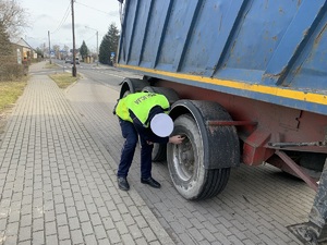 policjant sprawdza stan techniczny kontrolowanego auta