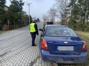 policjant kontroluje auto osobowe