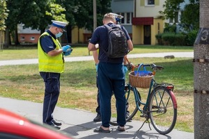 policjant kontroluje rowerzystę, zdjęcie ilustracyjne