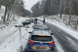 miejsce zdarzenia, na pierwszym planie radiowóz. w tle policjanci, strażacy i rozbite auto