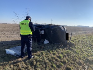 policjant na miejscu zdarzenia obok auto osobowe