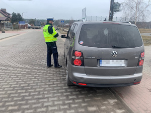 policjant kontroluje auto osobowe