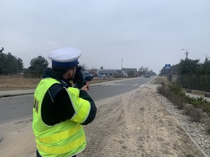 policjant mierzy prędkość w rejonie przejścia dla pieszych