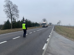 policjant zatrzymuje pojazd ciężarowy do kontroli