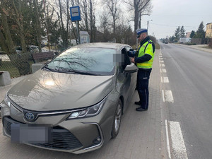 policjant kontroluje auto osobowe