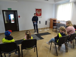 policjantka prowadzi spotkanie profilaktyczne dla dzieci siedzących w świetlicy