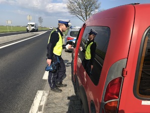 policjant kontroluje auto i rozmawia z kierowcą