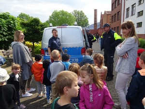 policjanci i dzieci stoją przy radiowozie