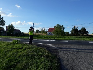 policjant mierzy prędkość aut urządzeniem