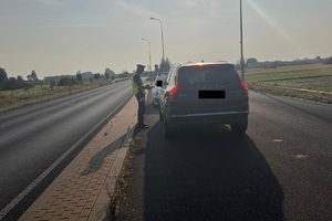 policjant kontroluje auto osobowe