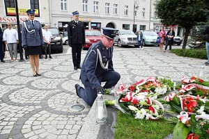 delegacja pod pomnikiem. przedstawiciel służby więziennej składa wiązankę kwiatów