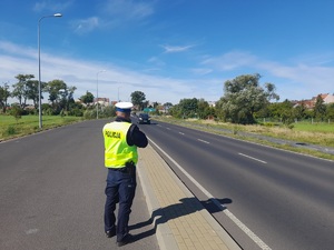 policjant mierzy prędkość w rejonie przejścia dla pieszych