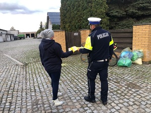 policjant przekazuje odblask kobiecie