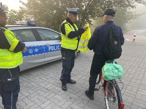 policjanci przekazują kamizelkę rowerzyście