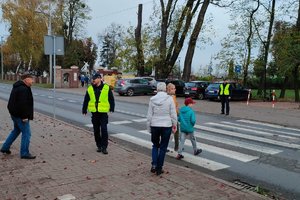 policjant nadzoruje pieszych na przejściu