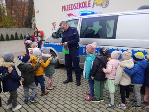 policjant rozdaje dzieciom odblaski