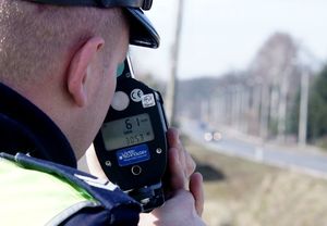 policjant mierzy prędkość urządzeniem