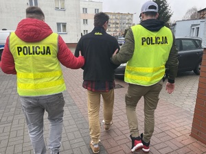 policjanci prowadzą osobę zatrzymaną