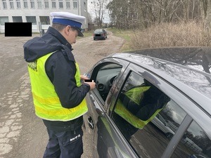 policjant kontroluje pojazd osobowy