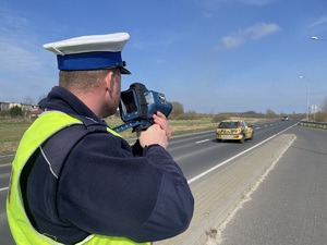 policjant mierzy prędkość urządzeniem