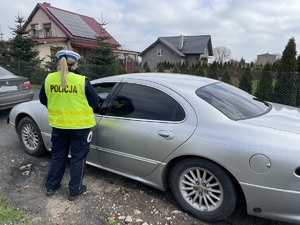 policjantka kontroluje pojazd osobowy koloru jasnego