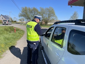 policjant kontroluje auto osobowe