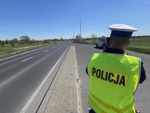 policjant mierzy prędkość auta urządzeniem