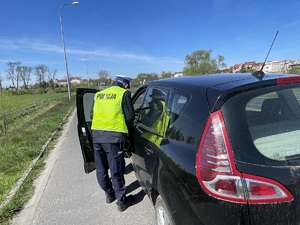 policjant kontroluje auto osobowe