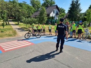 Policjant podczas egzaminu na kartę rowerową dla uczniów Szkoły Podstawowej w Laskownicy.